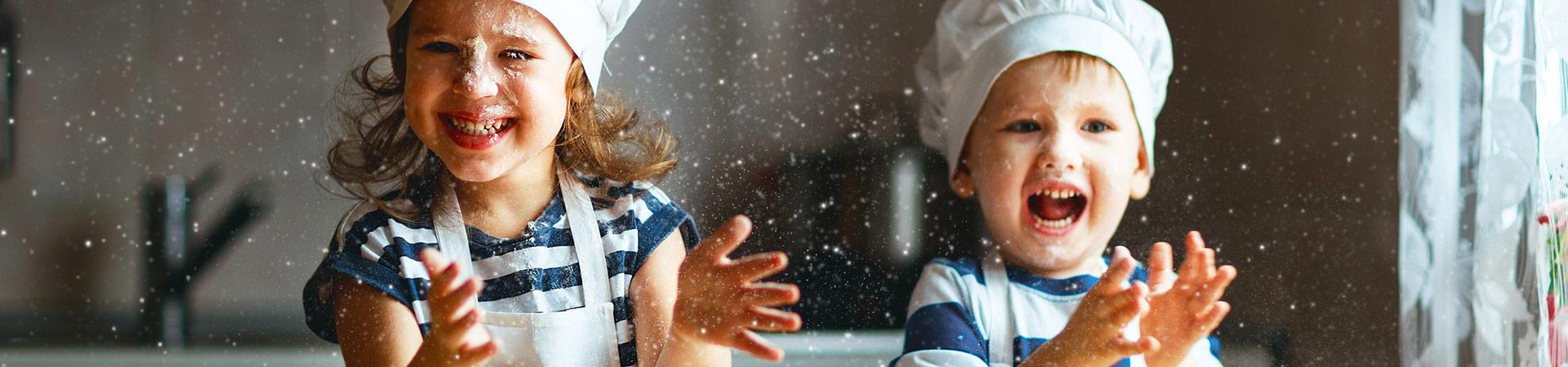 Flexi Renovations Perth Two joyful children wearing chef hats playfully tossing flour in a family kitchen during a fun baking activity together