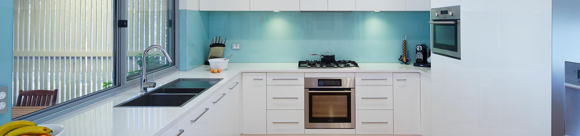 Flexi Renovations Perth Modern white kitchen with aqua glass splashback, sleek drawers, stainless steel appliances and chrome fixtures in Perth home