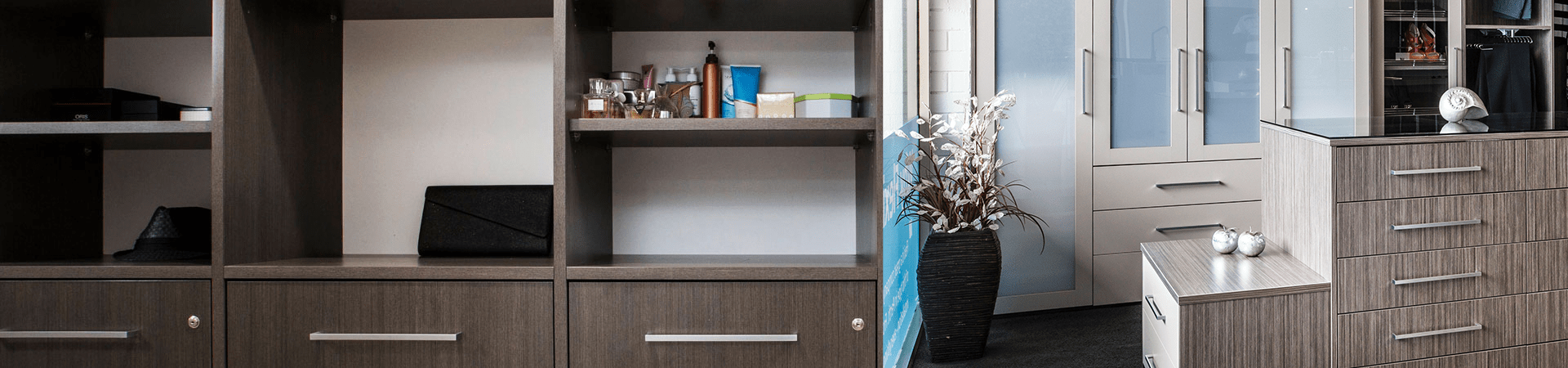 Flexi Renovations Perth Modern walk-in wardrobe showroom display featuring dark timber cabinetry, frosted glass doors, and organized storage solutions