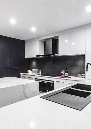 Contemporary minimalist kitchen in Myaree with white countertops and dark cabinetry. Modern kitchen design.