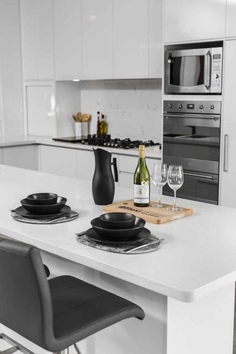 Modern kitchen design in Subiaco, Perth. Features white cabinetry, stone countertops, and stylish black serveware. A29V5211-683x1024.jpg