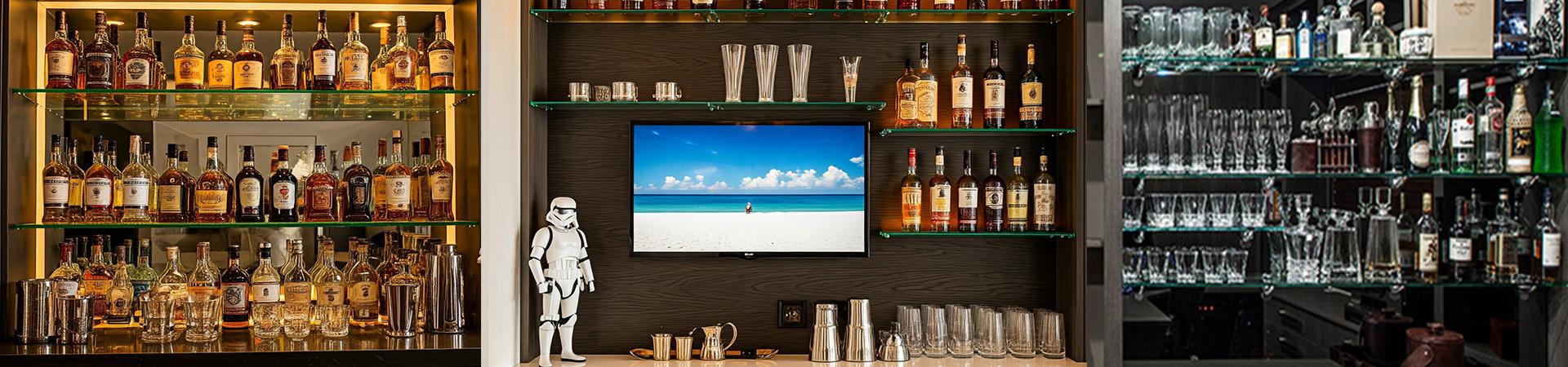 Flexi Renovations Perth Stylish home bar with glass shelving, premium liquor bottles, glassware display, TV screen, and custom cabinetry in Perth