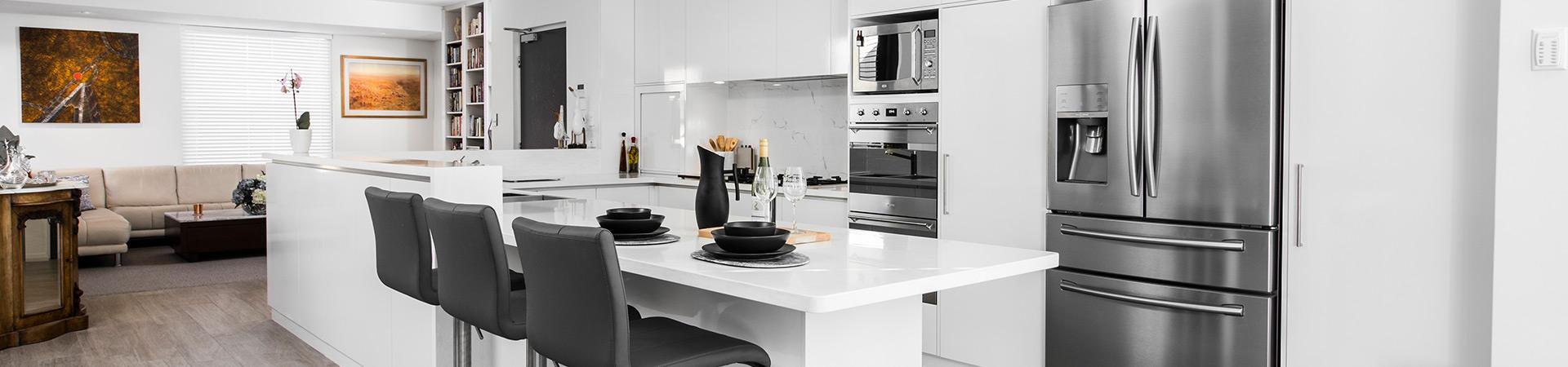 Flexi Renovations Perth Modern white kitchen zones design featuring island bench seating, stainless steel appliances, and open-plan living area