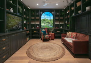 Heritage-inspired den in Floreat with dark built-in shelving, leather sofa, and a large window view.