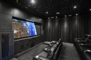 Intergalactic Home Cinema in Rivervale: Luxurious black leather seating, starry ceiling, and large screen displaying Earth.