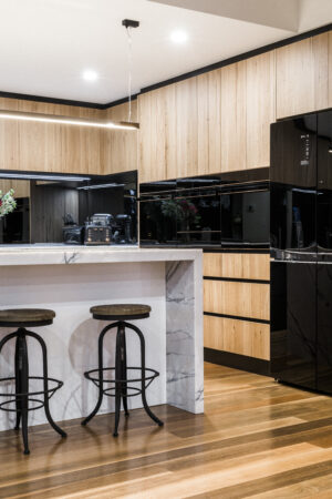 Modern rustic kitchen in North Coogee with wood cabinets, marble island, and black appliances. Stylish interior design.