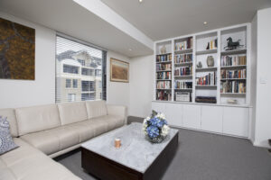 City retreat in Subiaco featuring a comfortable living room with a bookshelf, sofa, and a view from the window.
