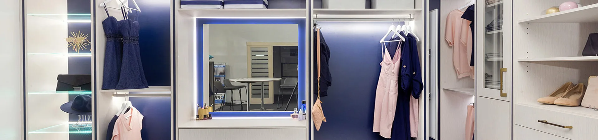 Flexi Renovations Perth Custom walk-in wardrobe with LED-lit vanity mirror, blue accent panels, hanging clothes, and display shelving in Perth home
