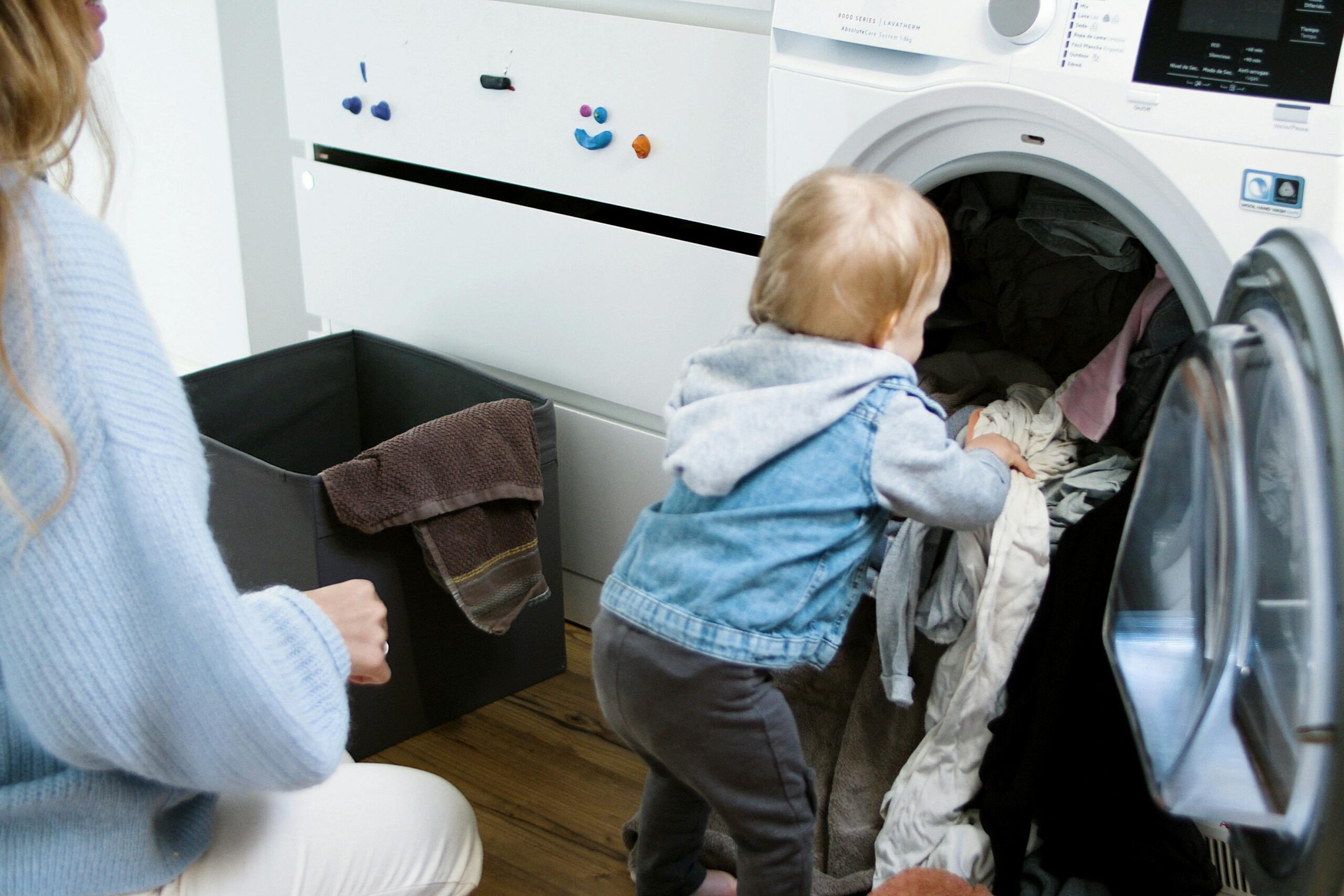 Luxury laundry renovation featuring a toddler helping with laundry in a bright, modern laundry room.